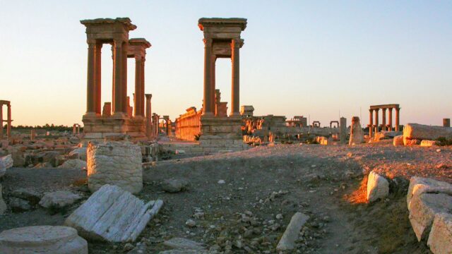 Ancient ruins stand bathed in warm sunlight.