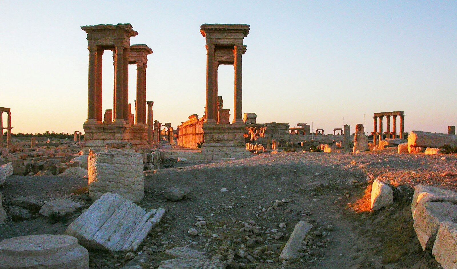 Ancient ruins stand bathed in warm sunlight.