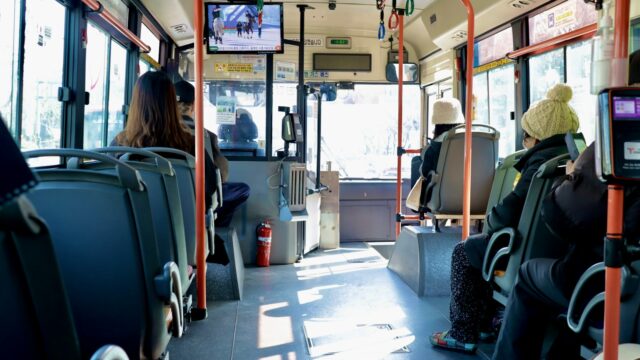 a group of people sitting on a bus next to each other